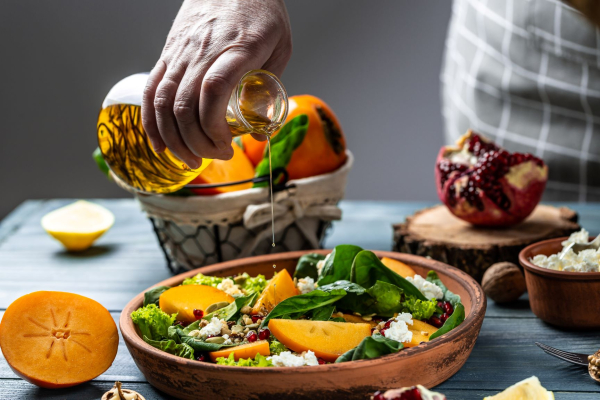 Gesunder Wintersalat mit Kakis, Spinat, Walnüssen, Ziegenkäse und ...